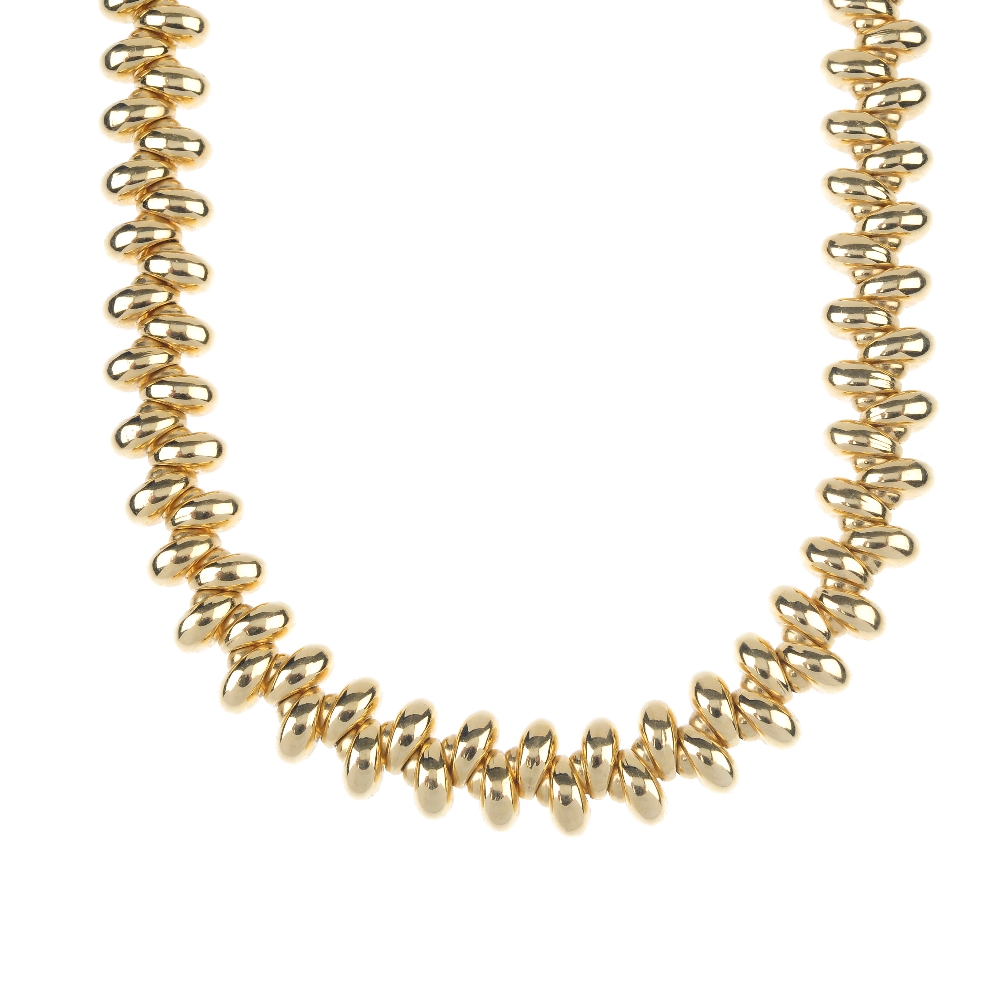 An 18ct gold collar. Designed as a series of tapered links, set at alternating orientations, to