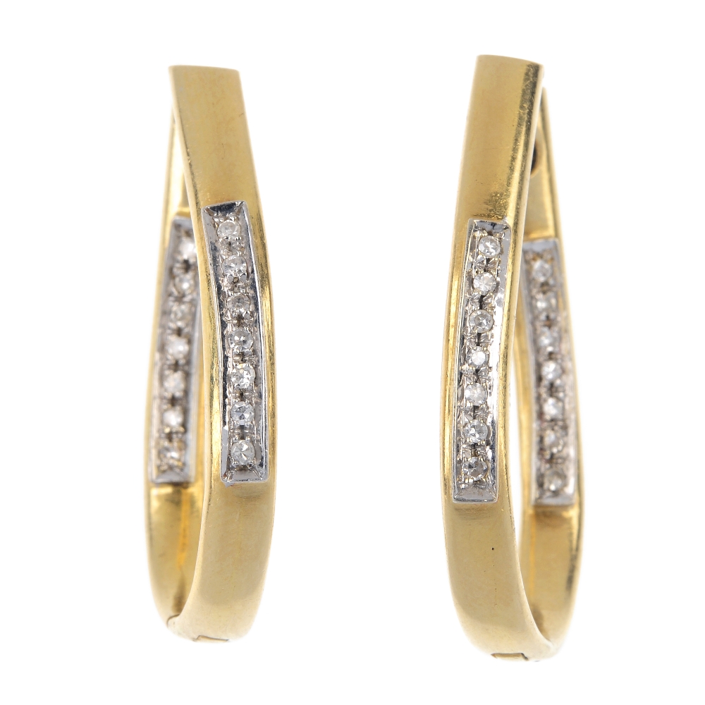 A pair of diamond ear hoops. Each design as an elongated hinged hoop, with single-cut diamond line
