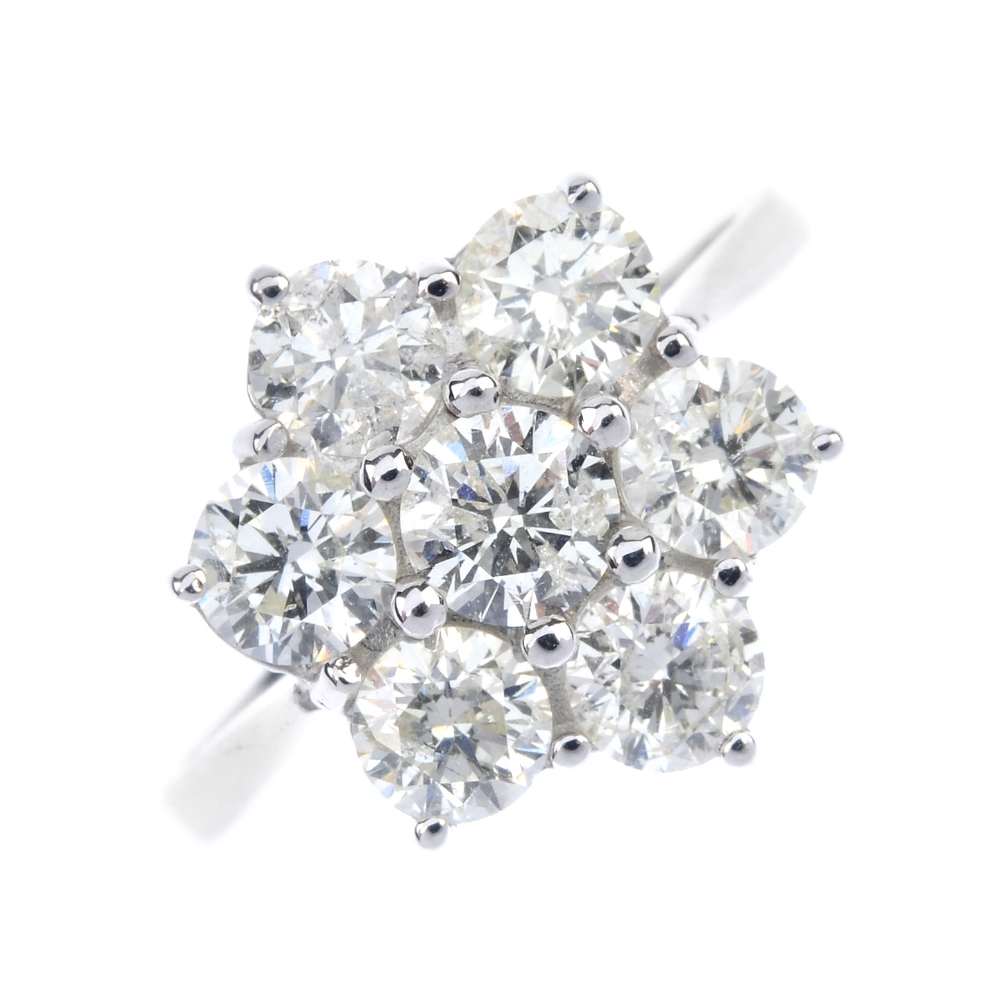 A diamond cluster ring. The brilliant-cut diamond, within a similarly-cut diamond surround, to the