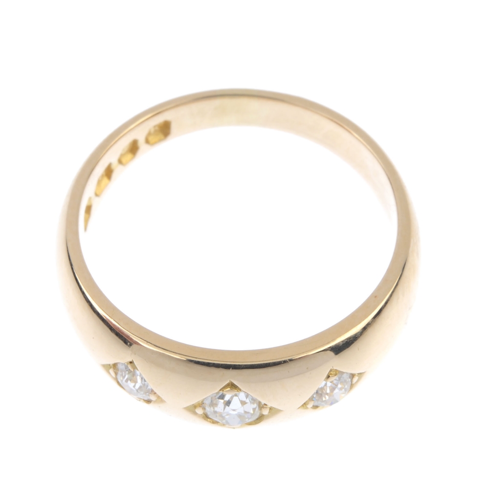 A late Victorian 18ct gold diamond three-stone ring. The graduated old-cut diamond line, inset to - Image 2 of 4