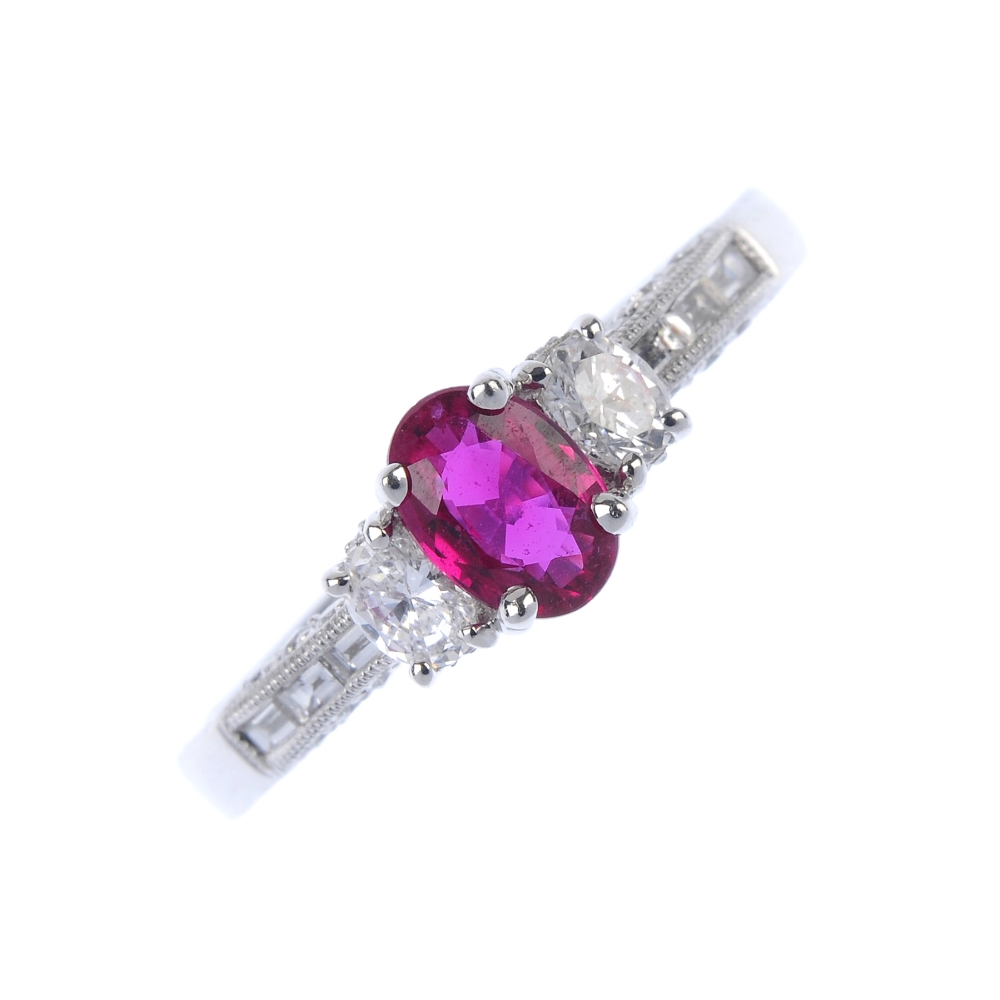 * An 18ct gold ruby and diamond dress ring. The oval-shape ruby and diamond sides, to the baguette-