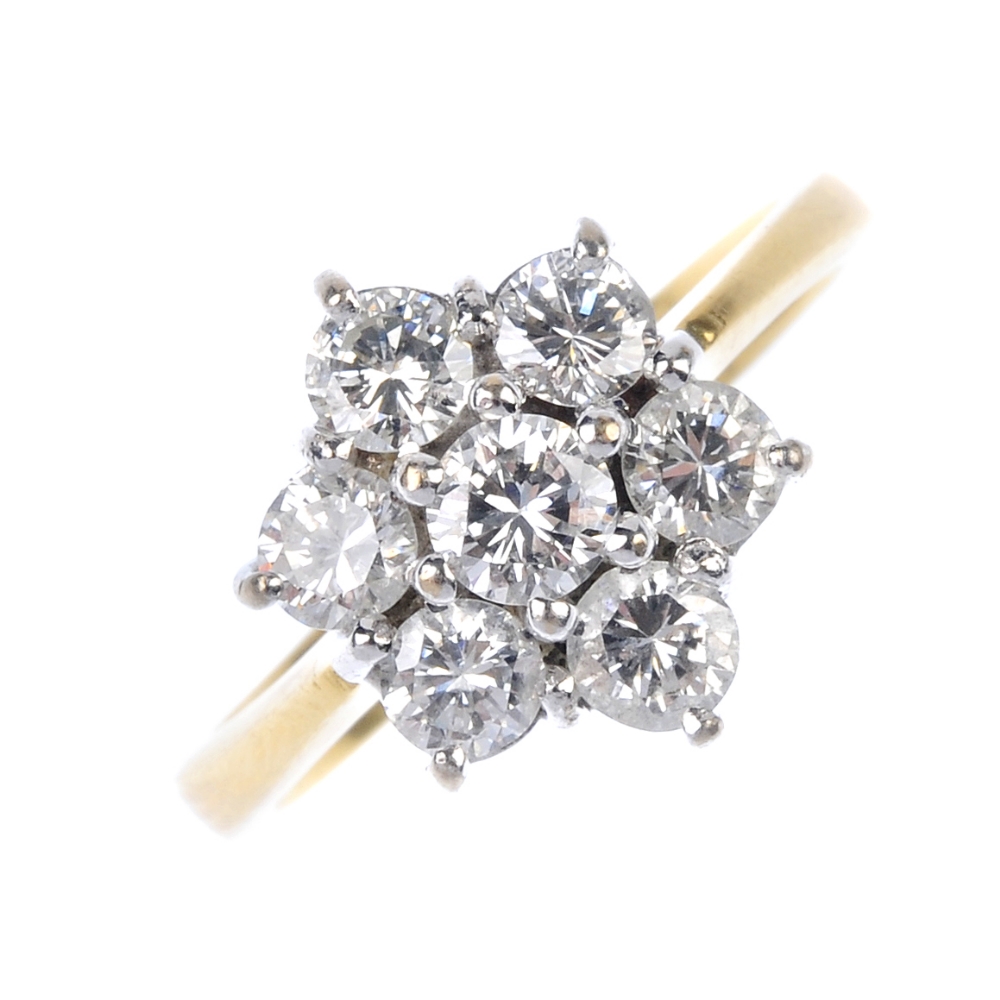 A diamond cluster ring. Of floral design, the brilliant-cut diamond cluster, to the tapered