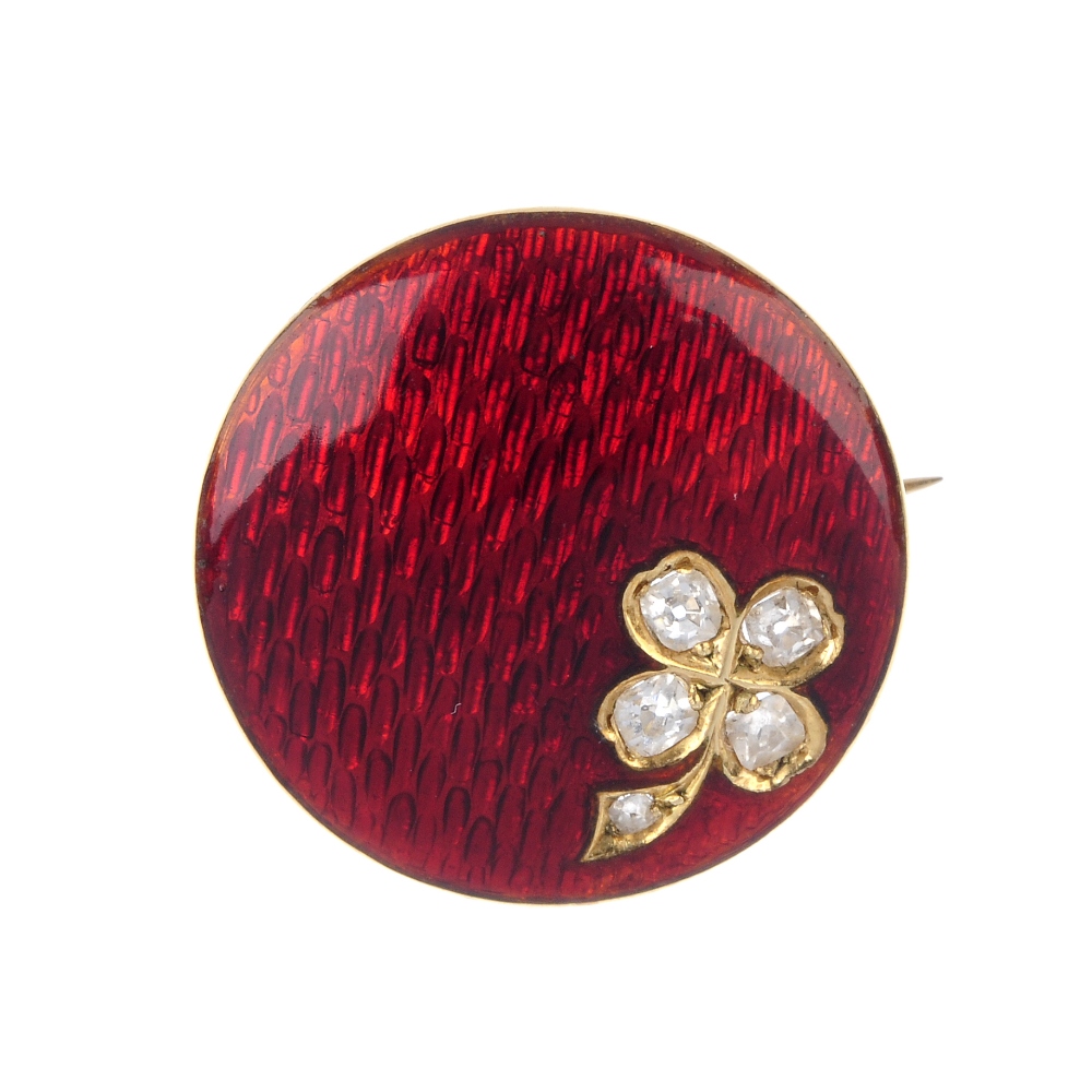 An early 20th century gold diamond and enamel brooch. The red guilloche enamel slightly domed