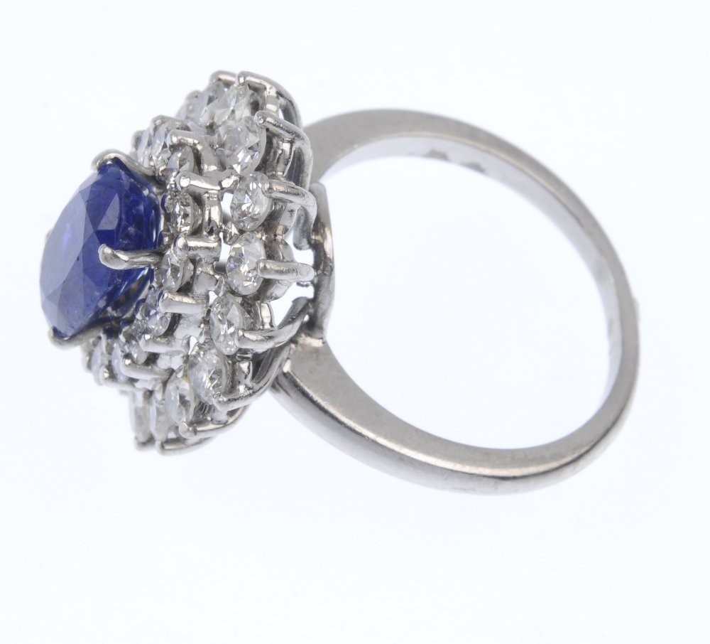 A sapphire and diamond cluster ring. The oval-shape sapphire, within a brilliant-cut diamond - Image 3 of 4