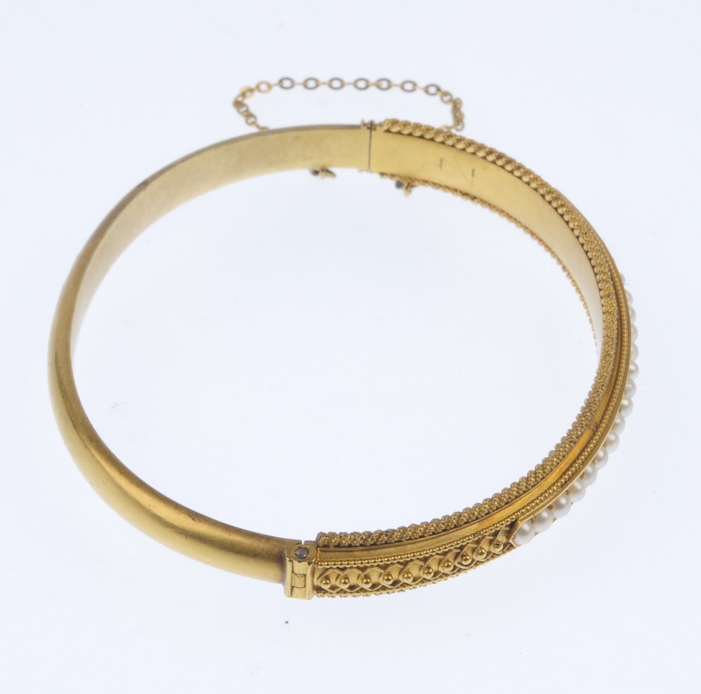A late 19th century gold split pearl hinged bangle. The split pearl line, to the bead accent sides - Image 2 of 4