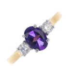 An 18ct gold amethyst and diamond three-stone ring. The oval-shape amethyst, with brilliant-cut