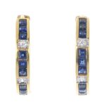 A pair of sapphire and diamond ear hoops. Each designed as a square-shape sapphire line, with