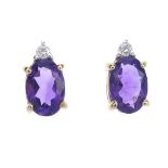 A pair of amethyst and diamond ear studs. Each designed as an oval-shape amethyst, to the