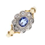 An 18ct gold sapphire and diamond cluster ring. The oval-shape sapphire collet, within a pave-set