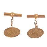 A pair of Edwardian 15ct gold cufflinks. Each designed as an engraved foliate motif oval-shape