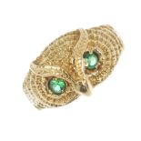 A novelty emerald ring. The textured owl mask, with circular-shape emerald eyes, to the slightly