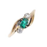 An early 20th century 18ct gold emerald and diamond three-stone ring. The cushion-shape emerald