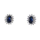 A pair of 18ct gold sapphire and diamond cluster ear studs. Each designed as an oval-shape sapphire,