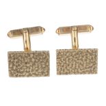 A pair of 1960s 9ct gold cufflinks. Each designed as a textured rectangular-shape panel, to the