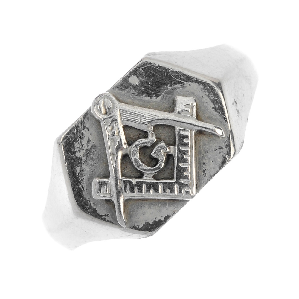 A Masonic signet ring. The hexagonal panel, depicting the square and compass symbol, to the
