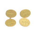 A pair of early 20th century 15ct gold cufflinks. Each designed as two oval panels, engraved with