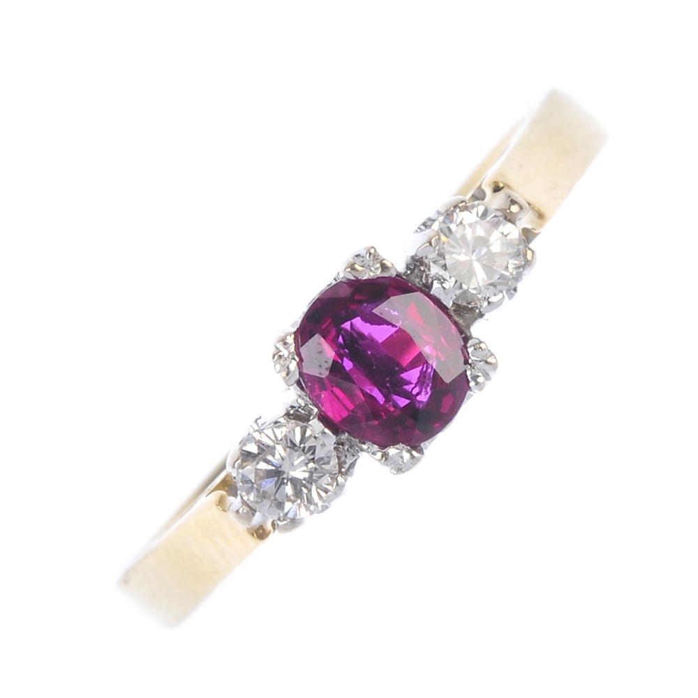 An 18ct gold ruby and diamond three-stone ring. The oval-shape ruby, with brilliant-cut diamond