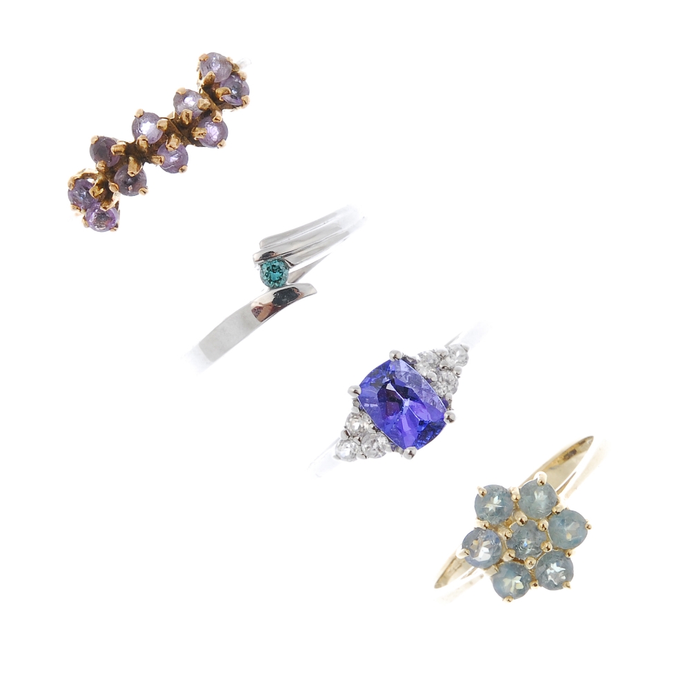 A selection of four 9ct gold gem-set dress rings. To include a coloured treated blue diamond