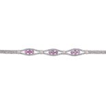 A ruby bracelet. Designed as three lines of circular-shape rubies, each with grooved spacers, to the