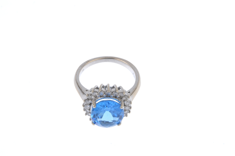 A 9ct gold topaz and diamond cluster ring. The oval-shape blue topaz, within a brilliant-cut diamond - Image 2 of 4