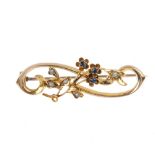 An Edwardian 15ct gold sapphire and split-pearl floral brooch. Of openwork design, the circular-