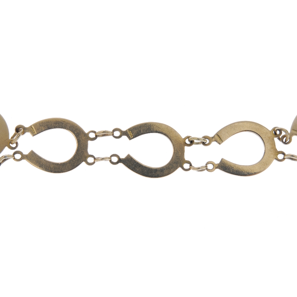 A 9ct gold horseshoe bracelet. Designed as a series of horseshoe links, to the spring ring clasp.