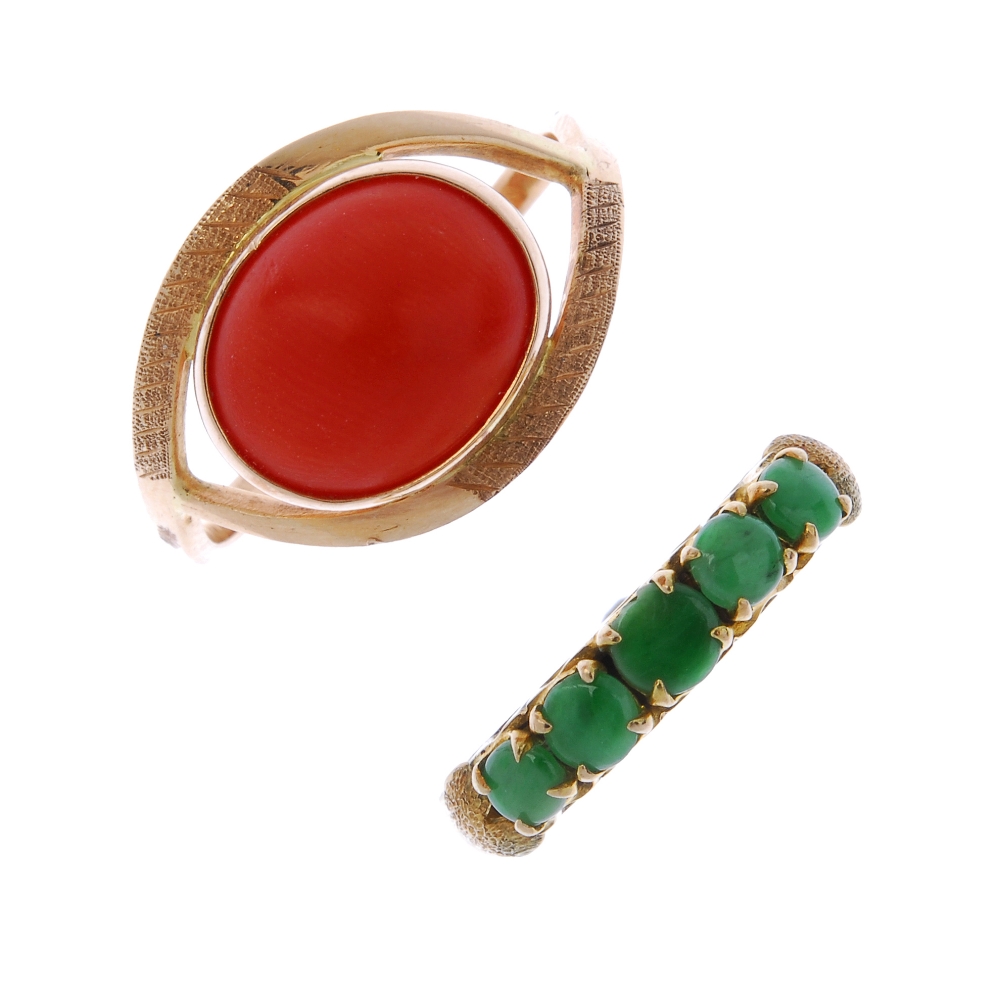 A coral ring and a jade ring. The first designed as an oval coral cabochon, within a tapered