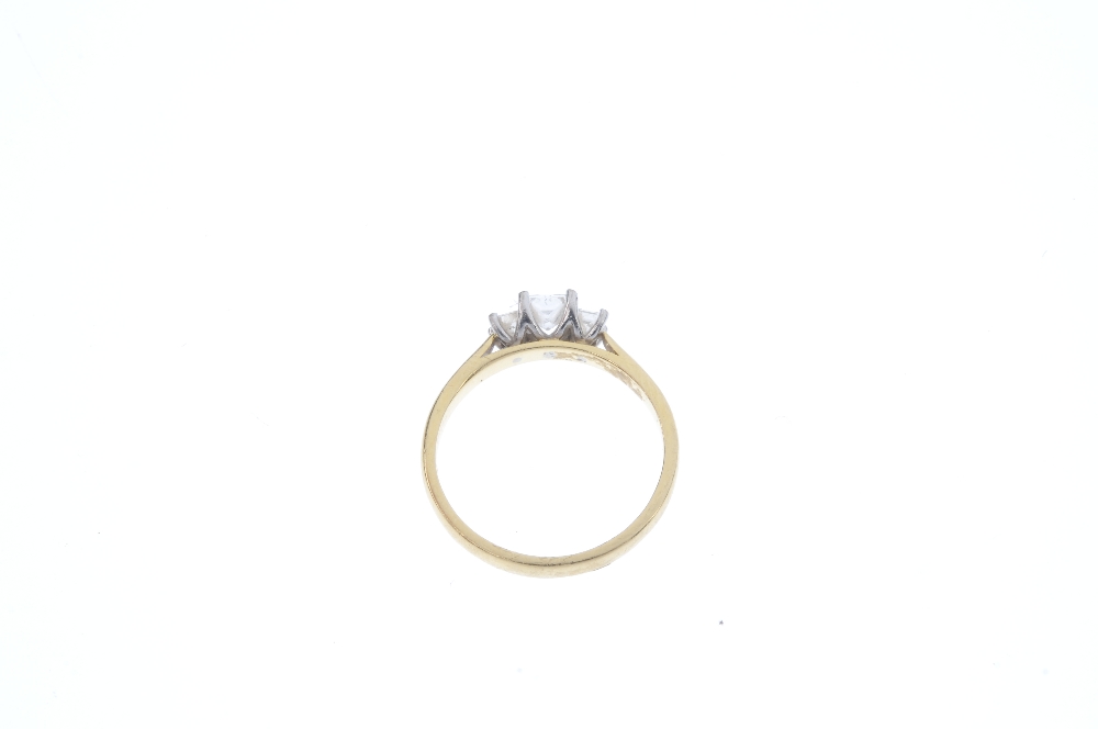 An 18ct gold diamond three-stone ring. The graduated square-shape diamond line, to the tapered - Image 4 of 4