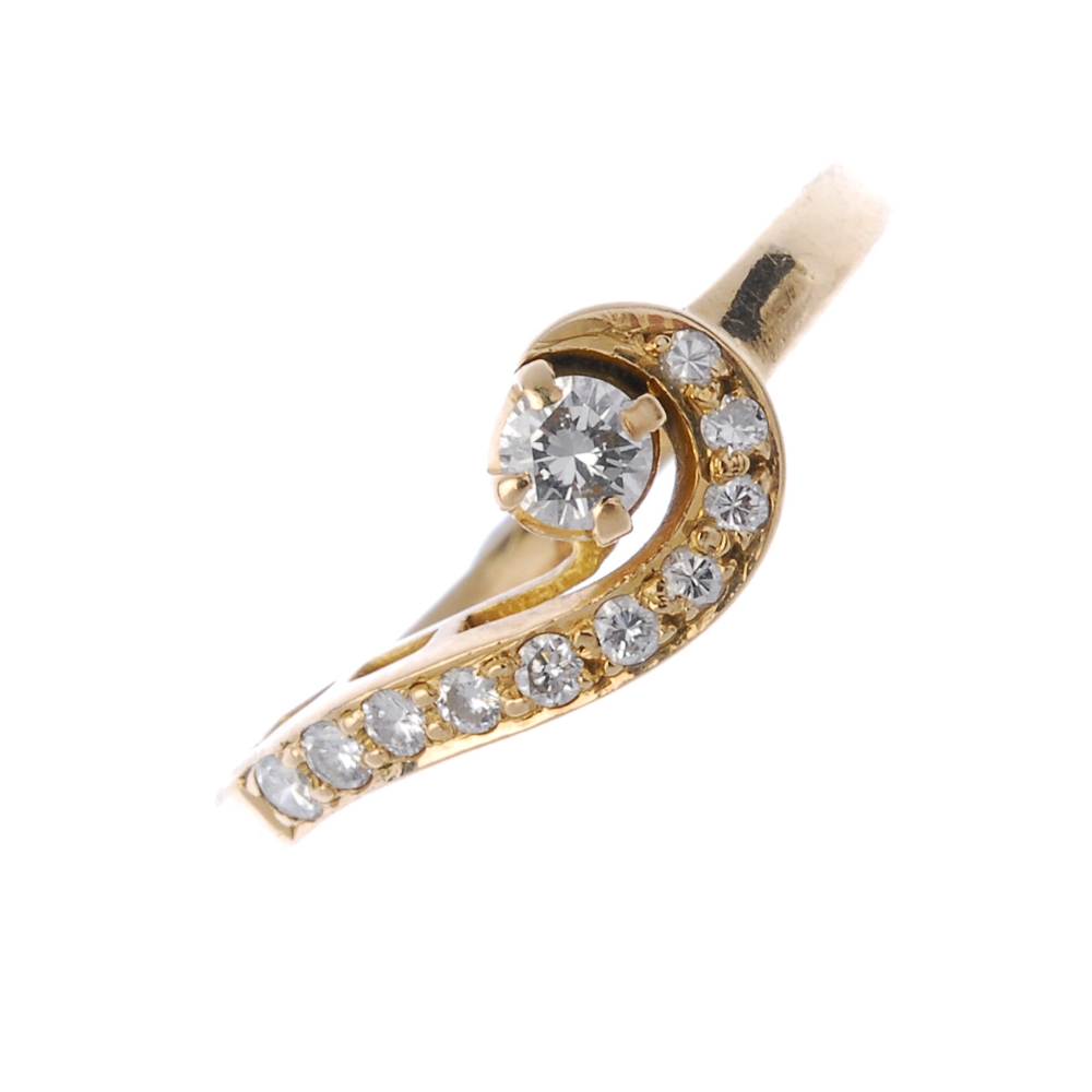 A 14ct gold diamond twist ring. The brilliant-cut diamond, to the graduated brilliant-cut diamond