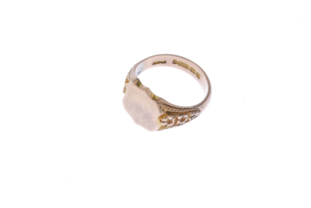 An early 20th century 9ct gold signet ring. The shield-shape panel, to the floral sides and plain - Image 2 of 4