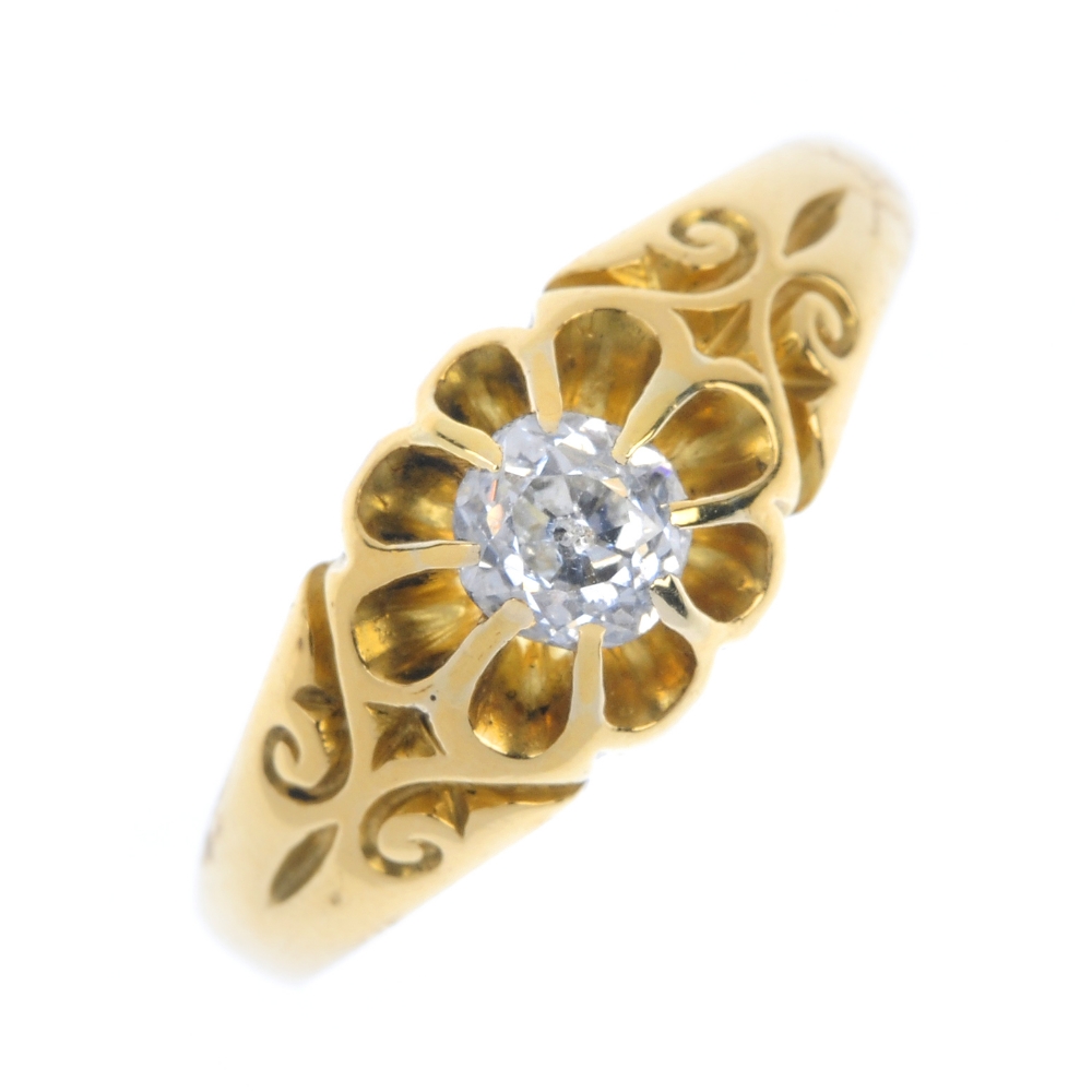 An 18ct gold diamond single-stone ring. The old-cut diamond, to the scrolling sides and