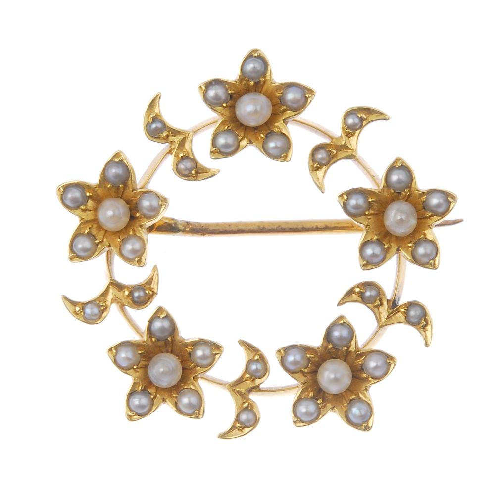 An early 20th century gold split and seed pearl wreath brooch. The split and seed pearl flowers with