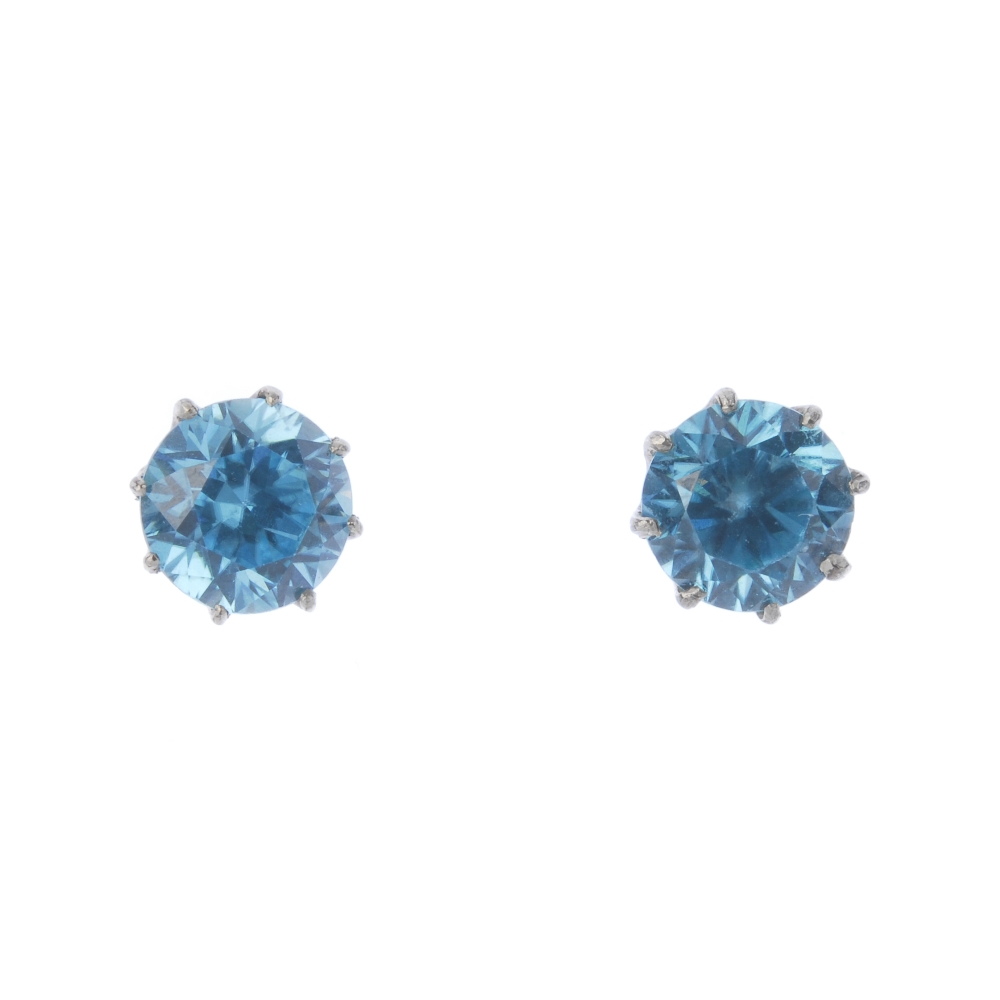 Two pairs of gem-set ear studs. A pair of circular-shape blue zircon ear studs and a pair of