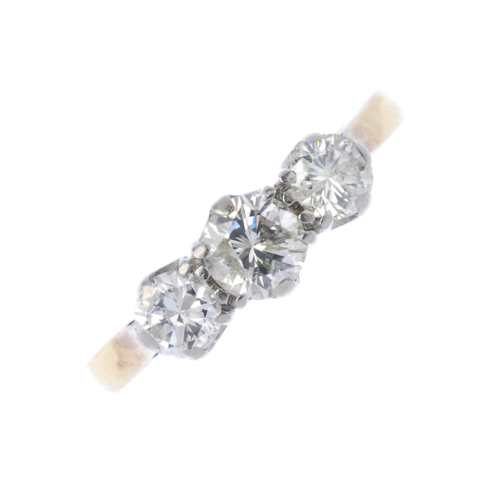 A mid 20th century 18ct gold and platinum diamond three-stone ring. The graduated circular-cut