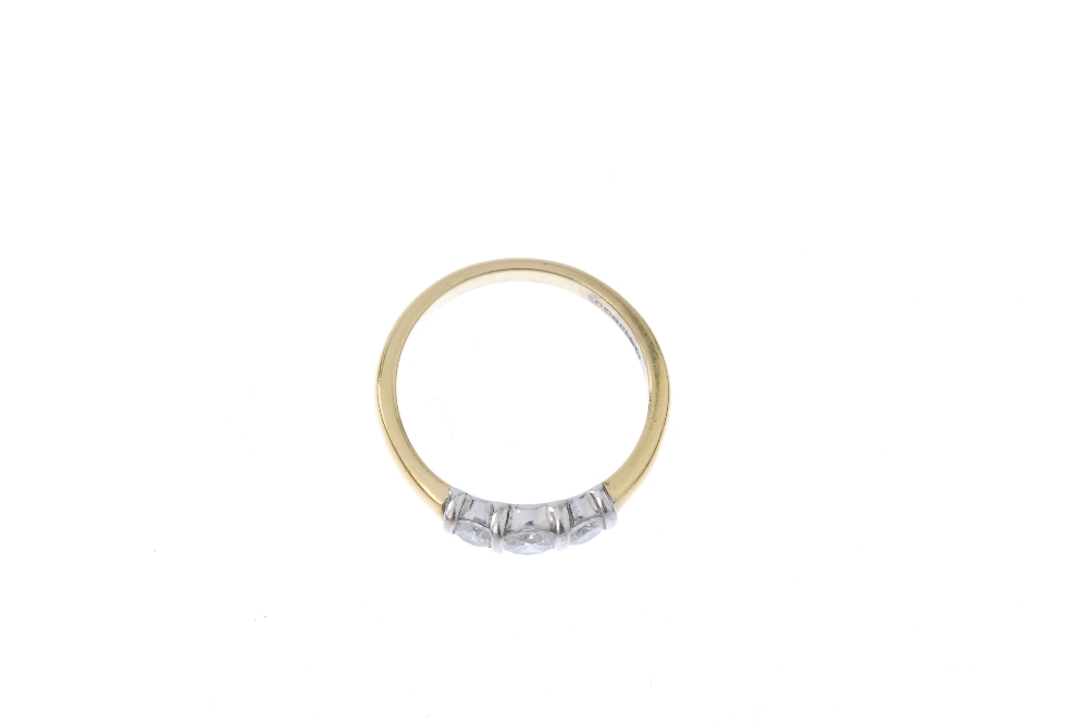 An 18ct gold diamond three-stone ring. The slightly graduated brilliant-cut diamond line, with bar - Image 2 of 4