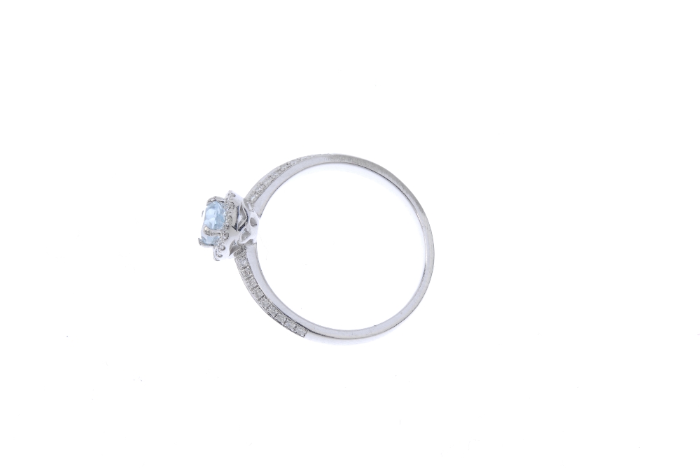 An aquamarine and diamond dress ring. The oval-shape aquamarine, within a brilliant-cut diamond - Image 3 of 4