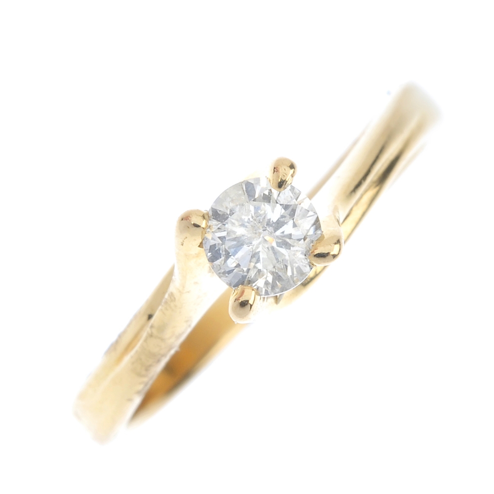 An 18ct gold diamond single-stone ring. The brilliant-cut diamond, to the spiral gallery and