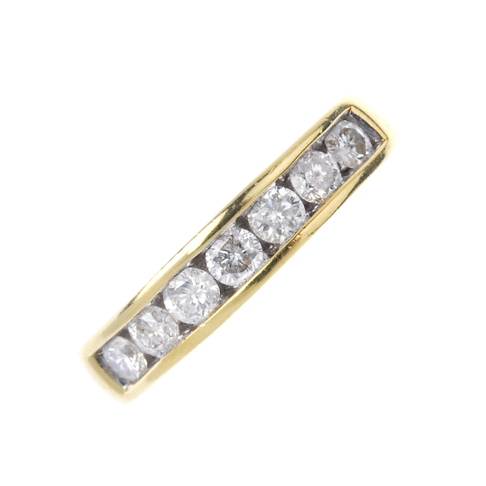 An 18ct gold diamond half-circle eternity ring. The brilliant-cut diamond line, to the tapered