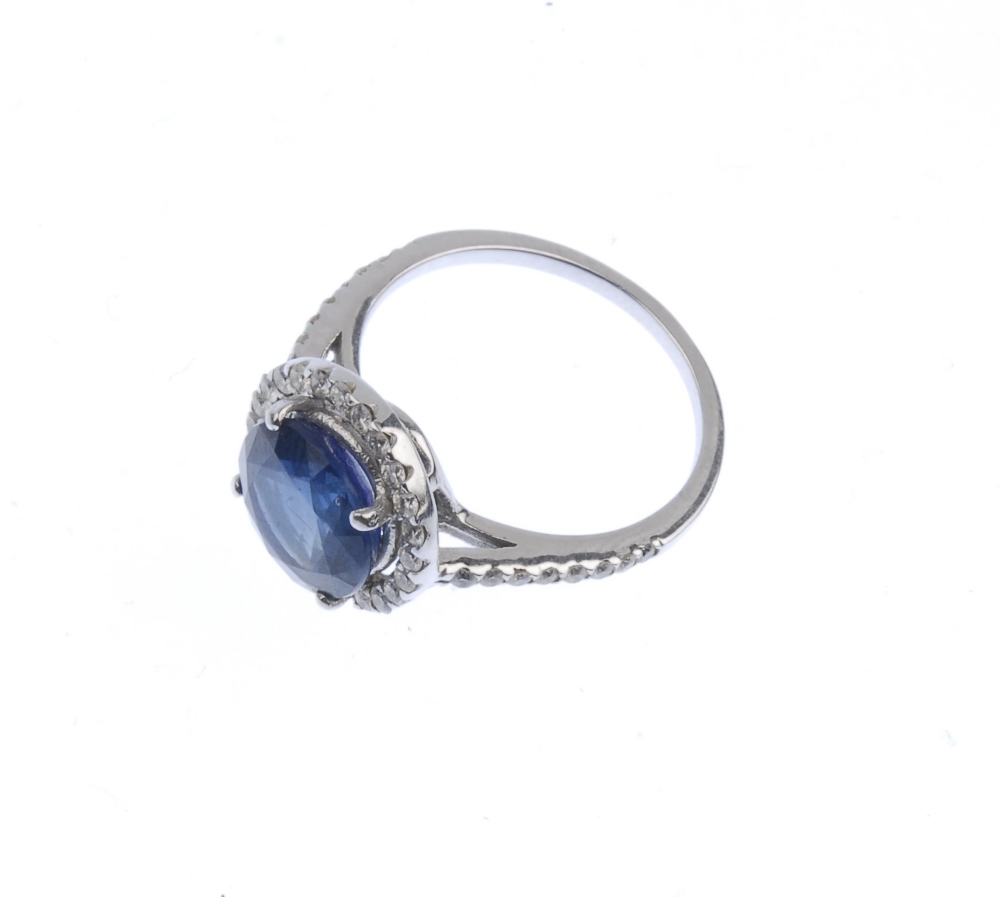 (539356-2-A) A sapphire and diamond cluster ring. The circular-shape sapphire, with brilliant-cut - Image 4 of 4