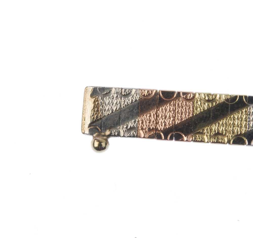 A 9ct gold bracelet. Comprising a series of tri-colour textured lines, with polished asymmetric line - Image 3 of 4