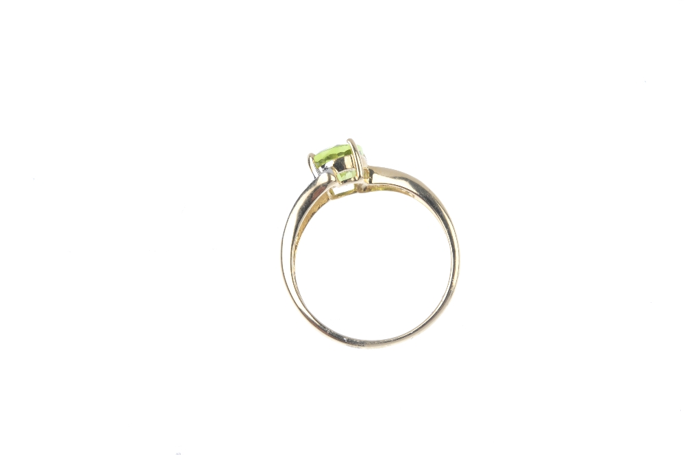 A 9ct gold peridot and diamond crossover ring. The oval-shape peridot, to the single-cut diamond - Image 4 of 4