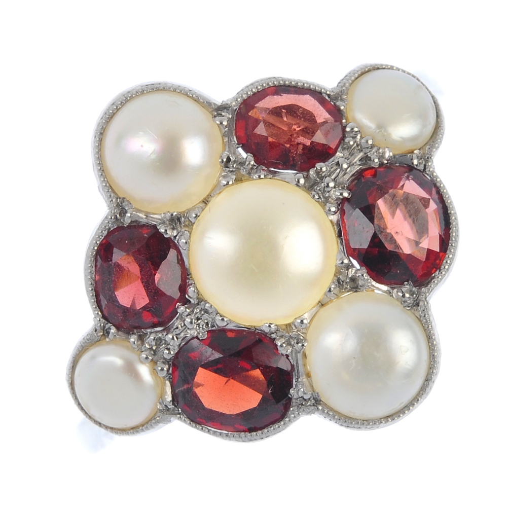 A freshwater cultured pearl and garnet cluster ring. The freshwater cultured pearl and oval-shape