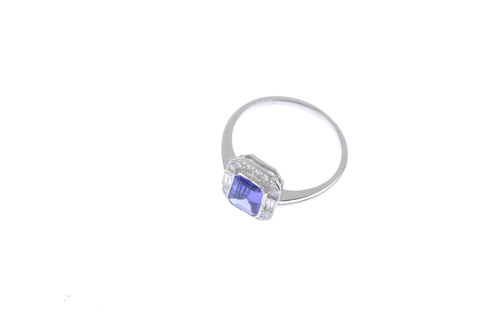 A tanzanite and diamond cluster ring. The rectangular-shape tanzanite, within a brilliant-cut - Image 2 of 4