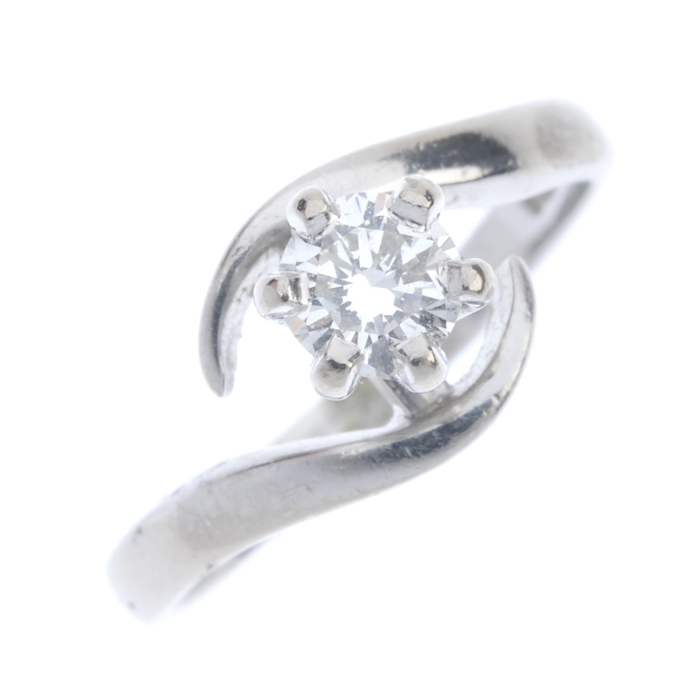 An 18ct gold diamond single-stone ring. The brilliant-cut diamond, to the asymmetric curved