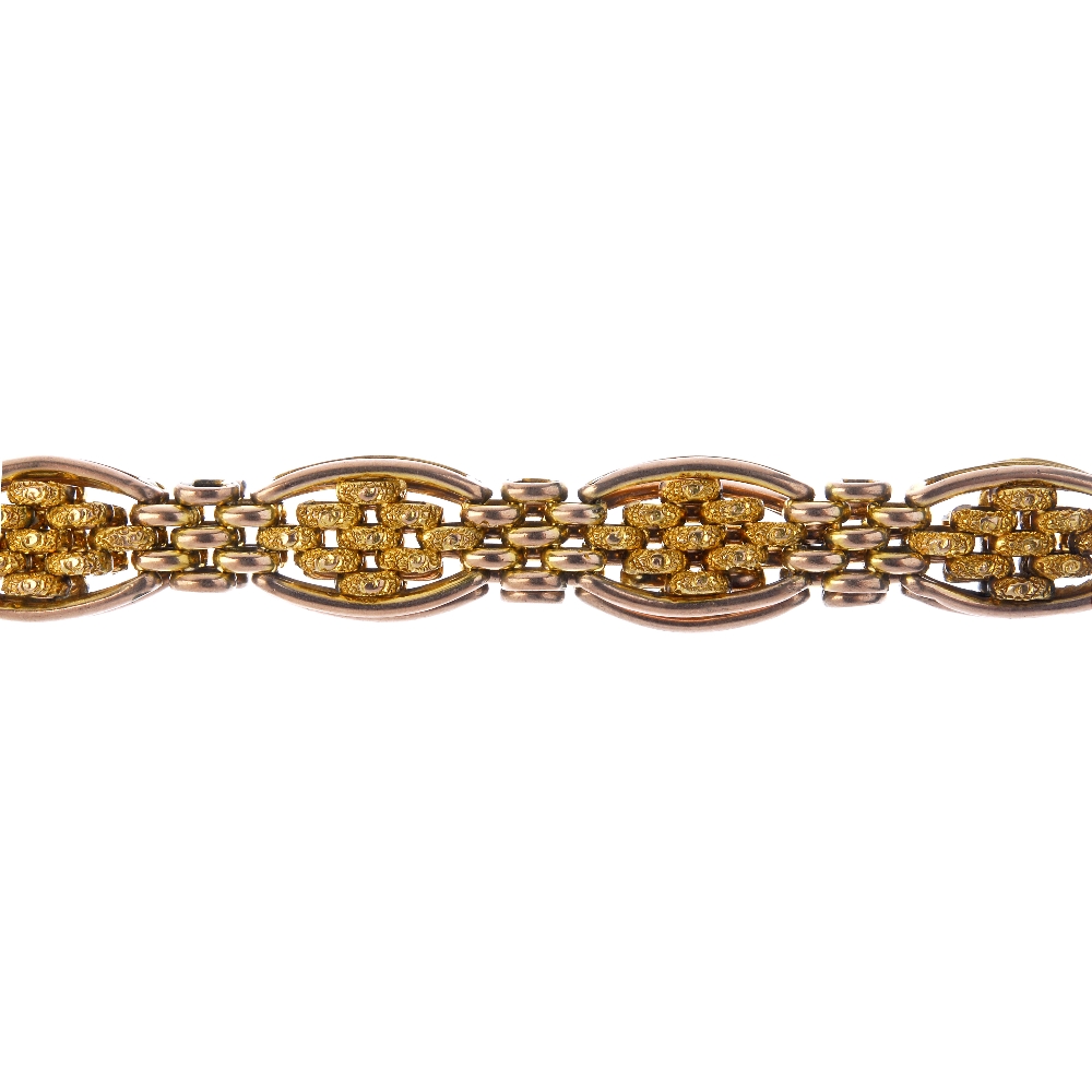 An early 20th century 9ct gold bracelet. Designed as a series of textured brick-link panels, with