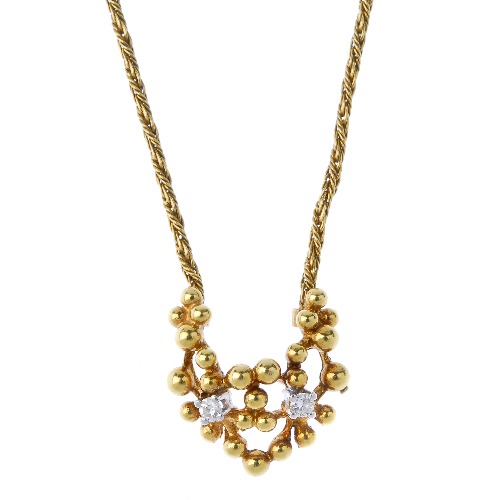 An 18ct gold diamond pendant. Of openwork design, the bead panel, with brilliant-cut diamond