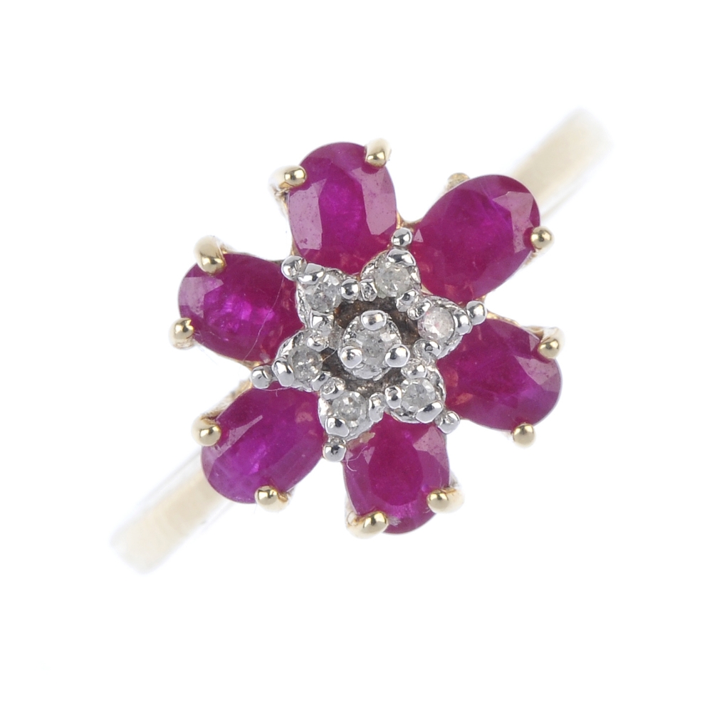 A 9ct gold diamond and ruby floral cluster ring. The single-cut diamond stepped cluster, within an
