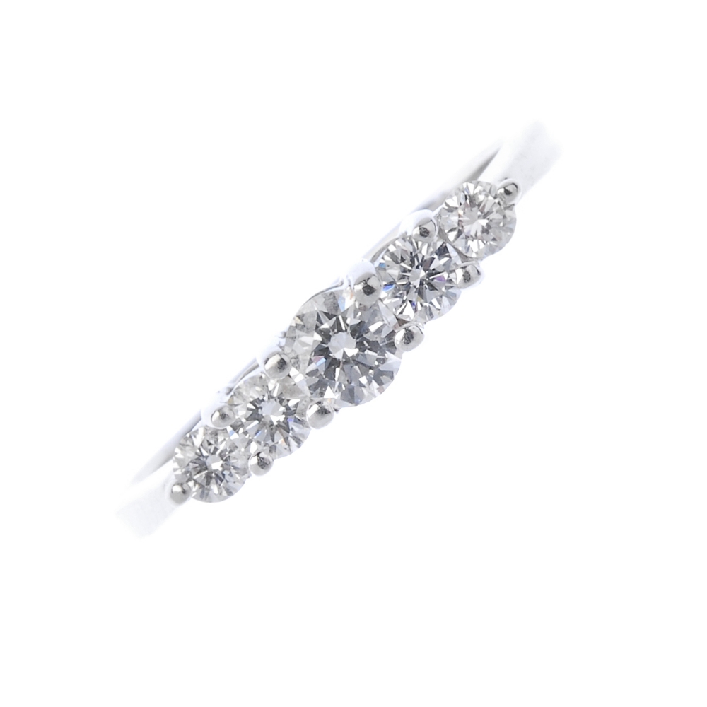 A diamond five-stone ring. The graduated brilliant-cut diamond stepped line, to the tapered