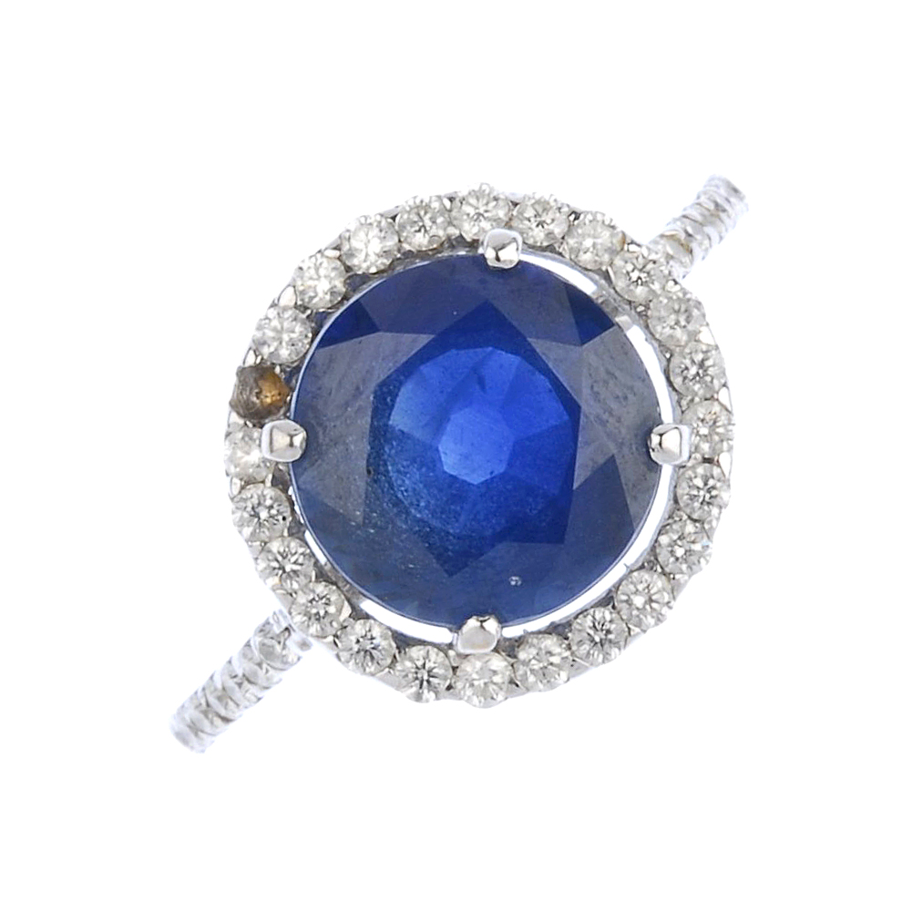 (539356-2-A) A sapphire and diamond cluster ring. The circular-shape sapphire, with brilliant-cut