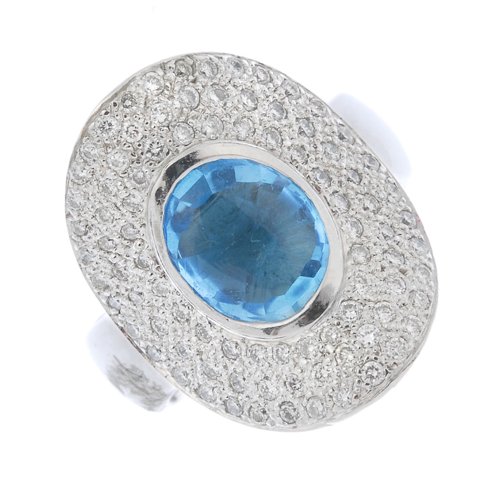 A topaz and diamond dress ring. The oval-shape blue topaz collet, within a pave-set diamond curved